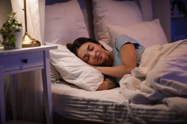 Young woman sleeping peacefully in bed in evening at home